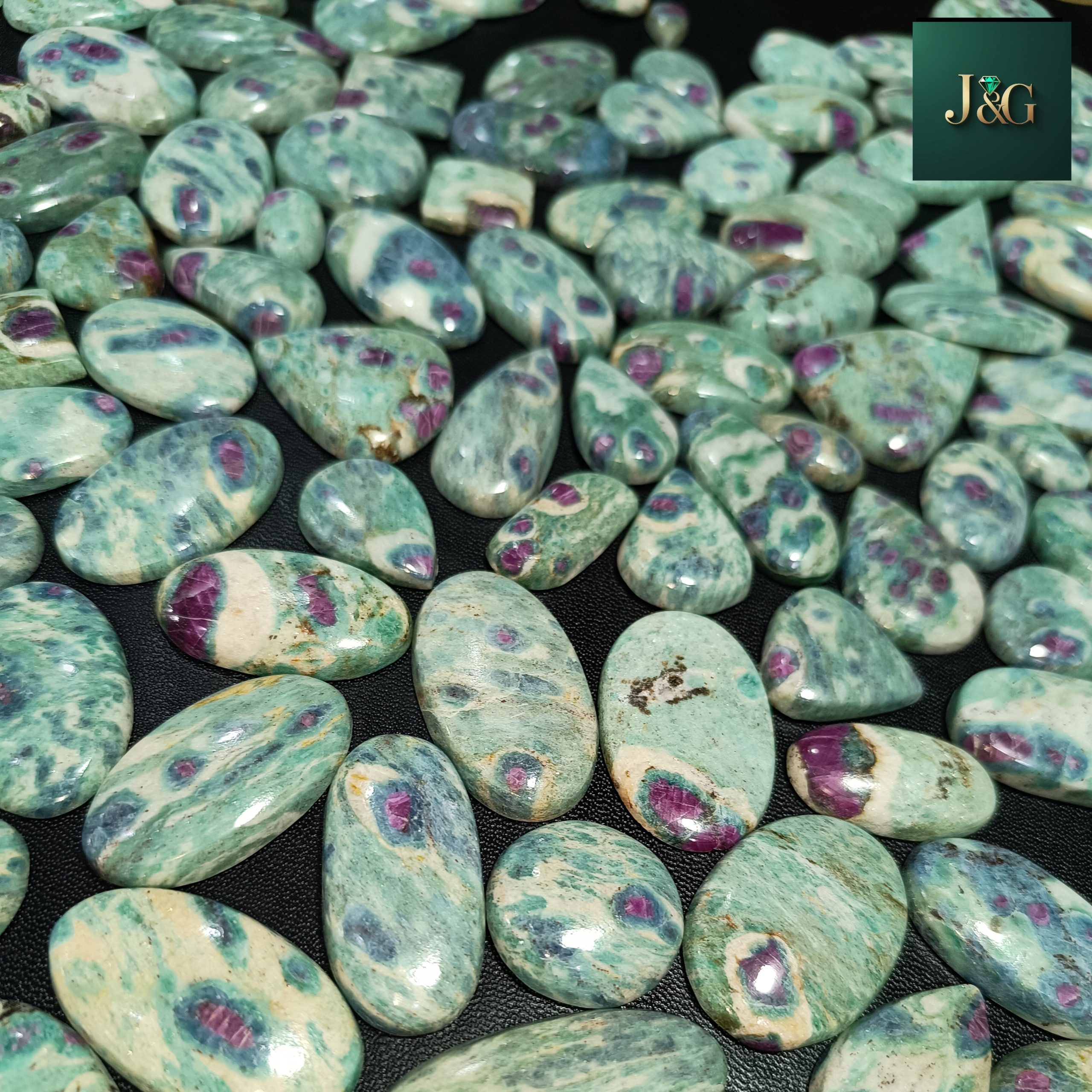 Natural Ruby Fuchsite cabochons with polished dome tops and flat backs for easy setting. Wholesale lots available, perfect for jewelers, artisans, and crystal lovers.
